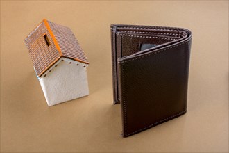 Little model house beside a wallet in view