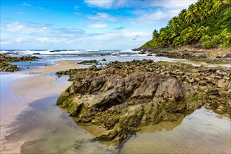 Rocky beach called Prainha surrounded by coconut trees and vegetation located in the city of Serra Grande on the south coast of the state of Bahia