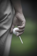 Golfer Holding a Golf Ball and a Tee