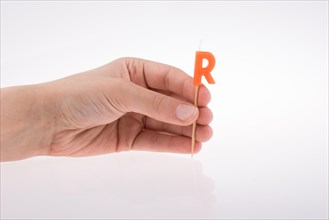 Color candle in hand on sticks writes the letter R