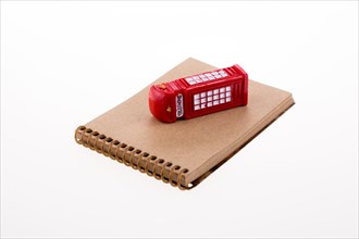 Isolated telephone booth on a spiral note book on white background