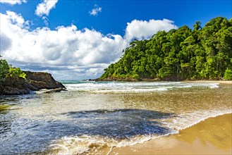 River flowing into the sea at the idyllic Ribeira beach surrounded by tropical forest in Itacare on the coast of Bahia