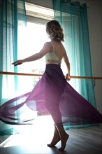 Woman Dancing with Transparent Skirt in Front of a Window with Curtain