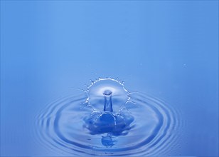 Drop of Water falling against Bleu background