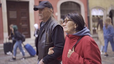 Elderly couple of tourists are walking through the historical center seeing the sights in an old European city. Palace Square