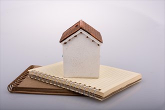 Little model house placed on an a brown color notebook