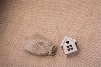 Model house beside a sack on a canvas background