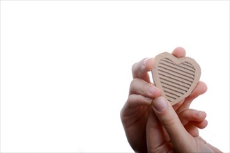 Isolated Heart shape hole through cardboard in hand