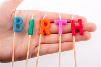 Color candles in hand on sticks write the word birth