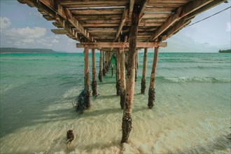 View of the waves and sea under a wooden boardwalk in Koh Rong Samloen in Cambodia