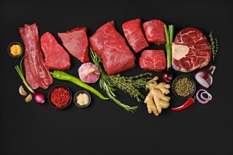 Top view of variety of fresh raw beef meat steaks with spice and herbs