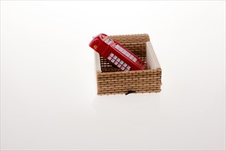Isolated telephone booth in a straw box on white background