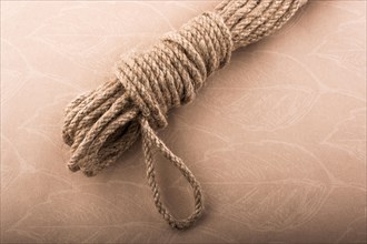 Bundle of linen rope in a sbrown background