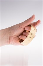 Hand with a golden bracelet on a white background