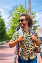 Portrait of smiling backpacker afro hair man on summer vacation