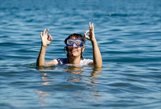 Woman with Diving Mask in the Water and Showing the OK Signal