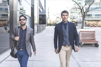 Two latin businessmen walking down the street