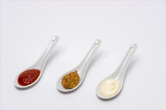 Spoons three sauces ketchup mayonnaise mustard white background