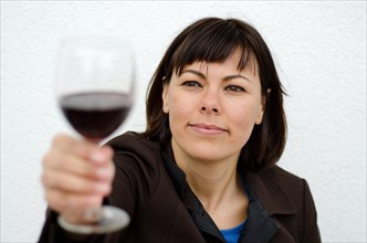 Woman Holding Up a Glass of Red Wine