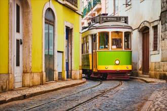Famous vintage yellow tram 28 in the narrow streets of Alfama district in Lisbon