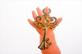 Doll holding a key on a white background