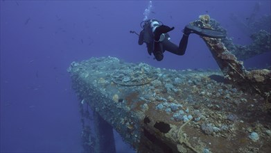 Scuba diver cameraman swims towards pipe of ferry Salem Express shipwreck