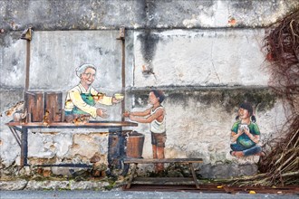 Street art granny serving food on a wall in George Town on Penang Island