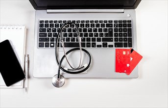 Stethoscope with credit cards on keyboard. Stethoscope on laptop keyboard with credit cards