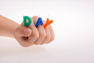 Color candles on sticks in hand write the word day