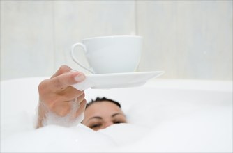 Woman Drinking a Coffee in the Bathtub with Foam