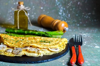 Mushroom omelette with wild asparagus on a slate