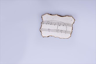 Musical notes on a burnt paper on a white background