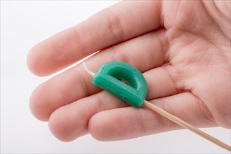 Color candle in hand on sticks writes the letter D