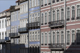 Row of houses with pastel-coloured facades and iron balconies