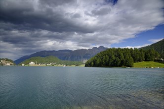 St Moritz Lake and Mountain and Green Trees with Grey Clouds in a Sunny Day in Switzerland