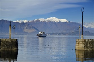 Ferry Boat on an Alpine Lake Maggiore with Snow-capped Mountain in Piedmont