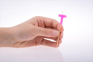 Color candle in hand on sticks writes the letter T