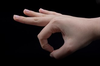 Hand gesturing sign ok okay agree on black background