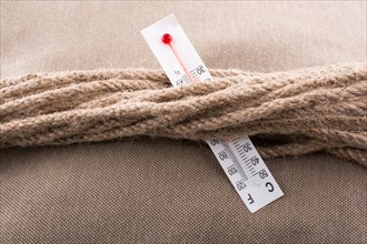 Thermometer placed on a brown rope on a fabric background