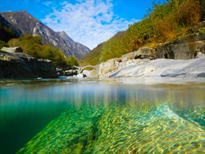 River with a Roman Bridge Ponti dei Salti and Trees and Mountain with Blue Sky and Clouds in Valley Verzasca in Ticino