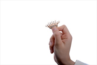 Golden color crown with pearls in hand on a white backgound