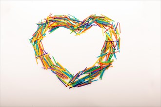Coloured wooden sticks form heart shape on white background