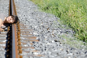 Woman Listening for a Incoming Train on the Railroad Track