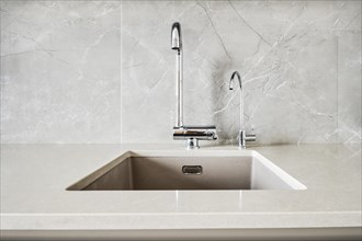 Front view of an elegant stone sink and water tap for pure water