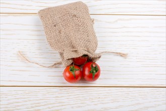 Little canvas sack and red ripe tasty fresh cherry tomatos