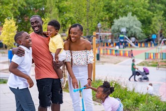 African black ethnicity family having fun with happy children together in playground