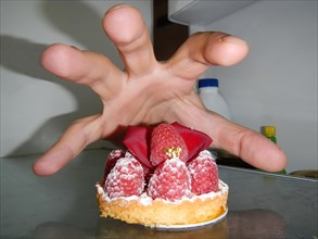 Hand take a raspberry cake in the fridge