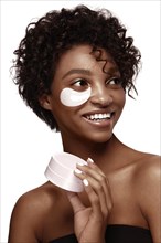 African American skincare models with perfect skin and curly hair with patches under her eyes