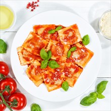 Ravioli Italian pasta eat lunch dish with plate in tomato sauce from above on wooden board square in Stuttgart