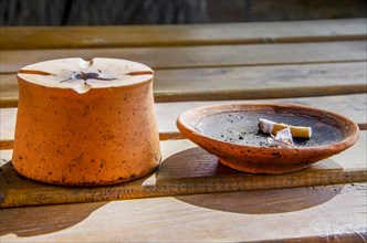 Stylish ashtray with cigarette butt on a wooden table